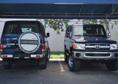 Two SUVs parked under shade